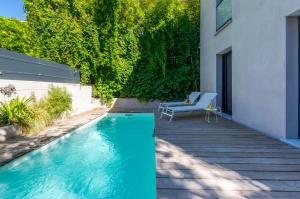 uma piscina com um banco ao lado de uma casa em Villa Arceaux - Premiere conciergerie em Montpellier