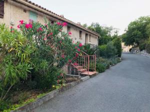 ein Haus mit rosa Blumen am Straßenrand in der Unterkunft La Lazarenco Piscine in Plan-de-la-Tour