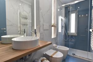 a bathroom with two sinks and a toilet and a shower at Dimora Al Castello in Matera