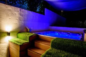 a jacuzzi tub with green chairs and a purple lighting at Beach Holiday home with private jacuzzi & parking in Trogir