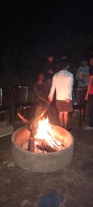 a person standing over a fire pit at night at KATAKERI HOLIDAY HOME in Madikeri