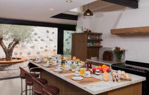 una cucina con tavolo e cibo di Historic Canarian House, Private Heated Infinity Pool, BBQ, WIFI + Panoramic Ocean Views ad Arona