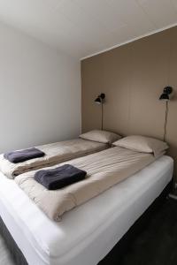 een slaapkamer met 2 bedden en handdoeken bij Ocean Break Cabins in Sandgerði