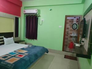 a bedroom with a bed and a window and a mirror at Ditto Room Hotel Kartik, Deoghar in Deoghar