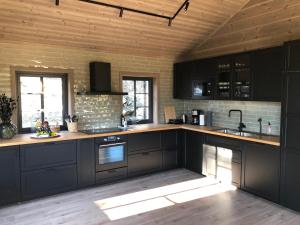 a kitchen with black cabinets and wooden ceilings at Hytte i Sogndal med panoramautsikt in Sogndal