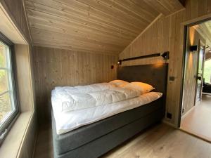 a bed in a room with a wooden wall at Høgerinden Lodge in Sogndal