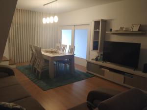 uma sala de estar com uma mesa e cadeiras e uma televisão em Brava em Vila Franca do Campo