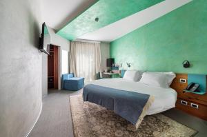 a bedroom with a large bed and a green wall at Carrick Hotel Camogli Portofino Coast in Camogli