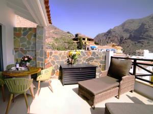 a patio with a table and chairs on a balcony at La Gomera Deluxe LOFT in Valle Gran Rey