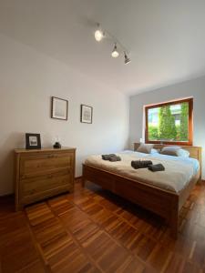 sypialnia z dużym łóżkiem i oknem w obiekcie La Playa Apartament z ogródkiem w mieście Hel
