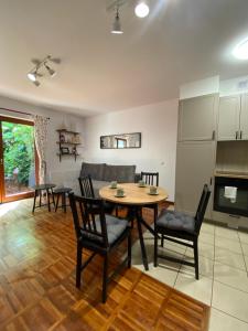 kuchnia i salon ze stołem i krzesłami w obiekcie La Playa Apartament z ogródkiem w mieście Hel