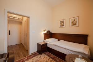 1 dormitorio con 1 cama, mesa y sillas en Hotel Grand en Uherské Hradiště