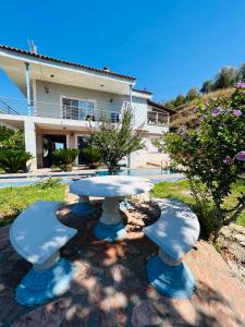 una mesa y asientos frente a una casa en Vieri apartments en Lukovë