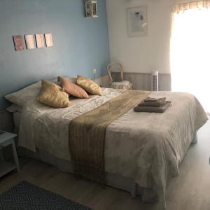 Un dormitorio con una cama grande con almohadas. en Les Landes en Saint-Pardoux-Corbier