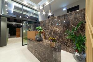 a lobby with a marble wall with potted plants at Lithos Suites - Nikiti Halkidiki in Nikiti +75 photos