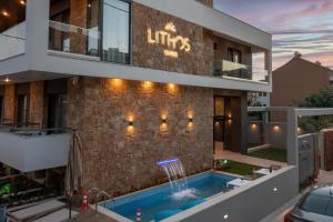 a building with a swimming pool in front of a building at Lithos Suites - Nikiti Halkidiki in Nikiti