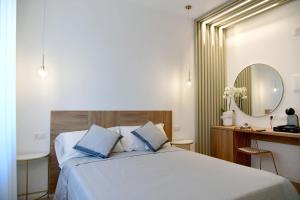 a bedroom with a bed and a desk and a mirror at Dimora Al Castello in Matera
