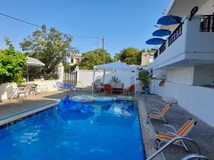 - une piscine dans une cour avec des chaises et une maison dans l'établissement VILLA ANNA, à Ravdhoúkha