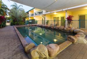 a swimming pool with rocks in front of a house at Sails On Horseshoe in Horseshoe Bay