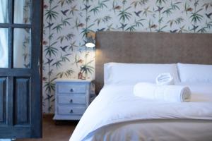 a bedroom with a bed with two rolled towels on it at Posada de Zorita de los Canes in Zorita de los Canes