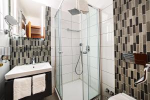 a bathroom with a shower and a sink at Holiday Club Apartman Hotel in Hévíz