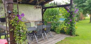 a table and chairs under a pergola with purple flowers at Srub Karpatský 