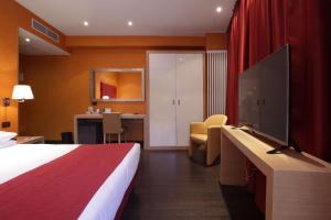 a hotel room with a bed and a flat screen tv at Best Western Hotel Piemontese in Bergamo