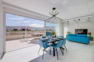 Tal-FranċiżにあるSuper Luxury Penthouse with Hot Tub and Poolのリビングルーム(テーブル、青い椅子付)