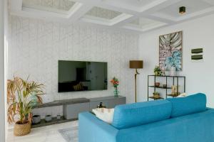 een woonkamer met een blauwe bank en een tv bij Super Luxury Penthouse with Hot Tub and Pool in Tal-Franċiż