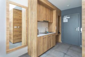 una cocina con armarios de madera y fregadero en Aparthotel Apartamenty Czarna Góra 138 en Sienna