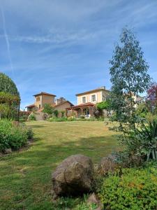 a house in a yard with a rock in the grass at La Grange Terrou in Saint-Germain-de-Confolens