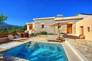 a villa with a swimming pool in front of a house at Villa Vicilla by PosarelliVillas in Fílippos