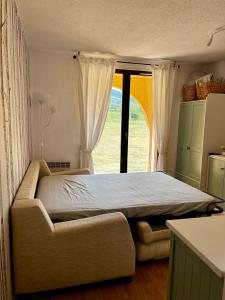 ein Schlafzimmer mit einem Bett und einem großen Fenster in der Unterkunft Val de Llous I 40 in Sainte-Léocadie