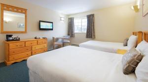 Postel nebo postele na pokoji v ubytování Fernie Slopeside Lodge