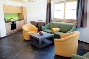 salon z kanapami, krzesłami i stołem w obiekcie Apartment Goaßa - Familie Zehner w mieście Göriach