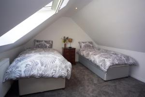 a attic bedroom with two beds and a window at Creggans Cottage in Creggans