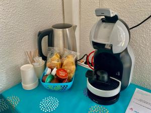 una macchinetta del caffè e un cesto di cibo su un tavolo di Hotel Oasis ad Argelès-sur-Mer