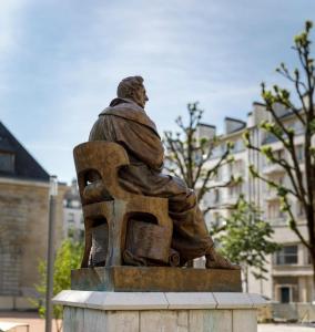 a statue of a man sitting on a chair at Vieille tour Hotel centre Rouen in Rouen +17 photos