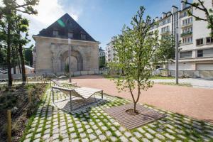 a park with benches and a tree in front of a building at Vieille tour Hotel centre Rouen in Rouen