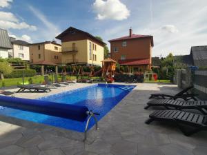 a swimming pool with chairs and a slide at Willa Cicha Basen Grota Solna Sauna in Rabka-Zdrój