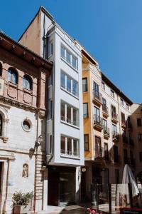 a tall white building in a city with buildings at Apartamentos BURGOSUITES in Burgos