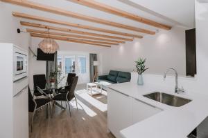 a kitchen and living room with a sink and a table at Apartamentos BURGOSUITES in Burgos
