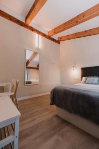 Un dormitorio con una cama, una mesa y un espejo. en Apartamentos BURGOSUITES, en Burgos