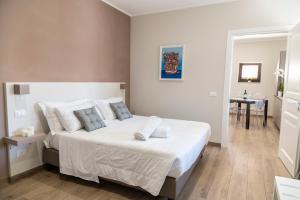 sypialnia z dużym łóżkiem z białą pościelą i poduszkami w obiekcie Ruggero Settimo - Room & Suite w mieście Palermo