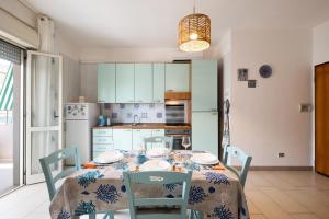 een eetkamer met een tafel en stoelen en een keuken bij Pineta Mare Flat in Gallipoli