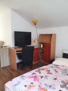 1 dormitorio con 1 cama y escritorio con TV en Casa Ana en Cluj-Napoca