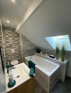 a bathroom with a large tub and a sink at Le Grenier Saint-Pierre in Verdun