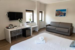 a living room with a couch and a bed and a desk at Ruggero Settimo - Room & Suite in Palermo