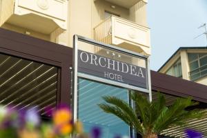 um sinal para um hotel em frente a um edifício em Hotel Orchidea em Cervia