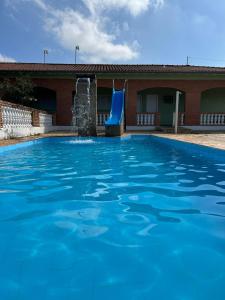 una piscina con scivolo d'acqua blu di Pousada das Estrelas a São Pedro